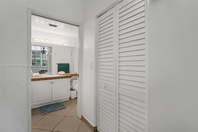 bathroom featuring tile patterned flooring, vanity, and toilet