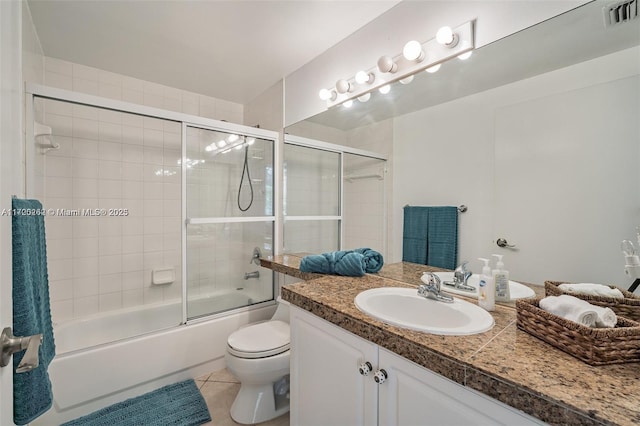 full bathroom featuring tile patterned flooring, vanity, toilet, and bath / shower combo with glass door