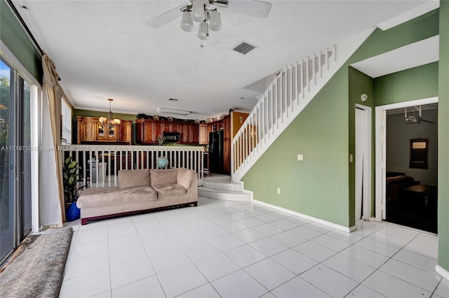 unfurnished living room featuring a textured ceiling, ceiling fan with notable chandelier, light tile patterned flooring, and crown molding