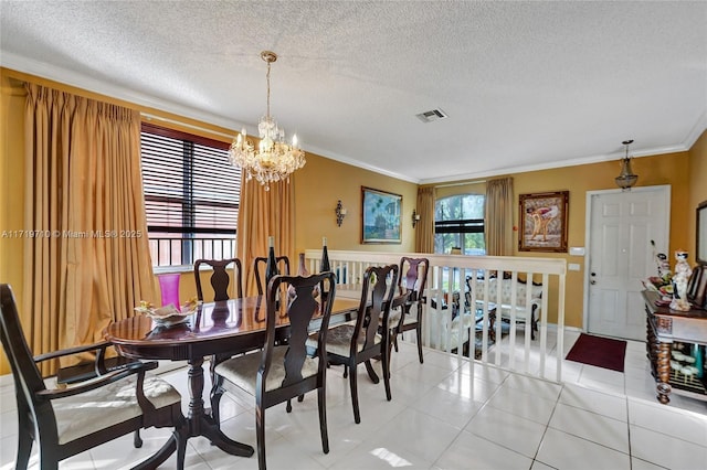 dining space with a textured ceiling, an inviting chandelier, tile patterned floors, and crown molding