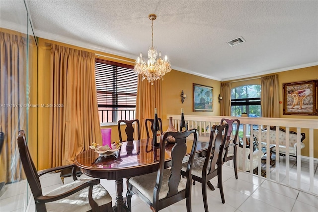 dining room featuring tile patterned flooring, a textured ceiling, a chandelier, and crown molding