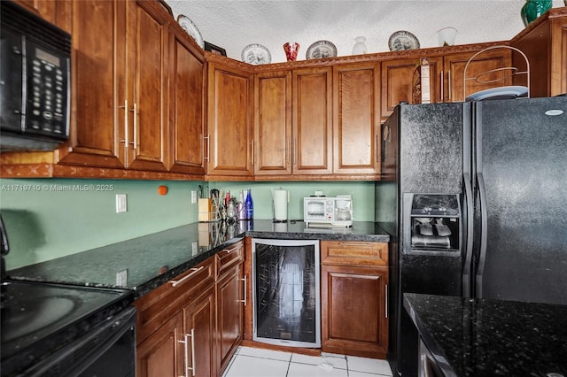 kitchen featuring wine cooler, dark stone counters, a textured ceiling, light tile patterned floors, and black appliances