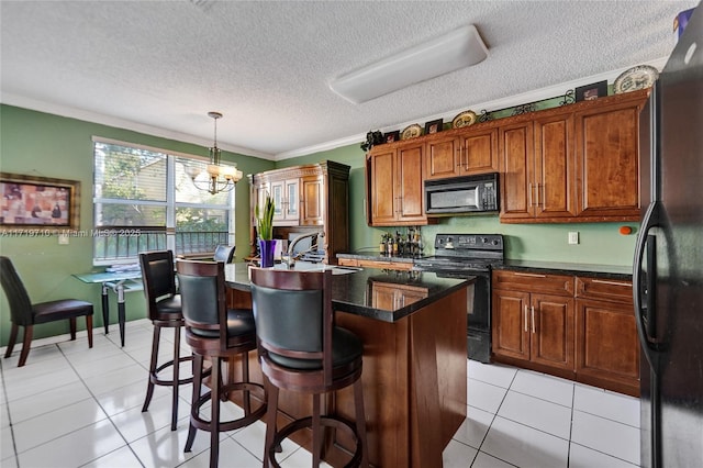 kitchen with sink, crown molding, pendant lighting, light tile patterned floors, and black appliances