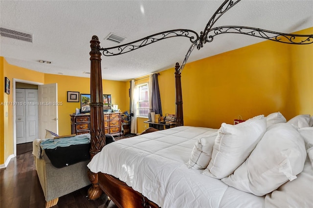 bedroom with dark hardwood / wood-style floors and a textured ceiling