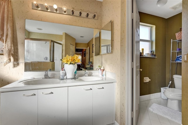 bathroom with tile patterned flooring, vanity, a shower with shower door, and toilet