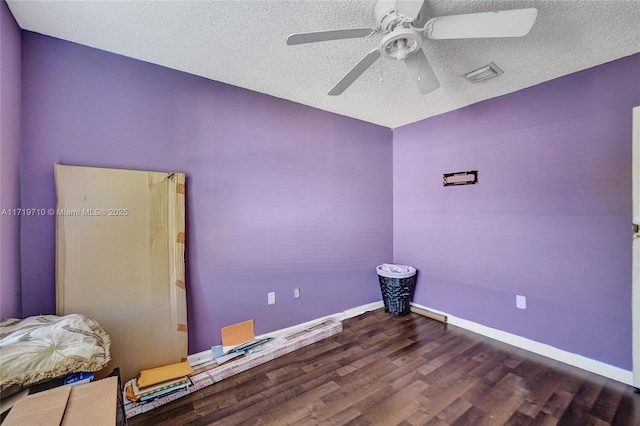 unfurnished room with ceiling fan, dark hardwood / wood-style floors, and a textured ceiling