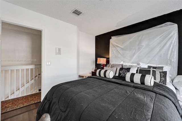 bedroom featuring hardwood / wood-style floors and a textured ceiling