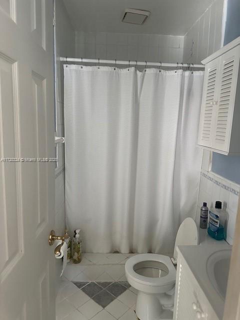 bathroom with tile patterned floors, vanity, toilet, and a shower with curtain