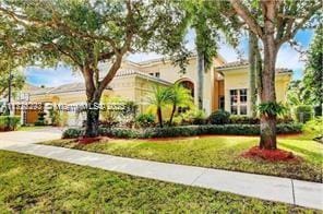 mediterranean / spanish home with a front lawn