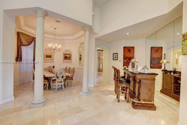 6139 Via Venetia S, Delray Beach, FL 33484 - bar with arched walkways, ornate columns, a chandelier, crown molding, and decorative light fixtures