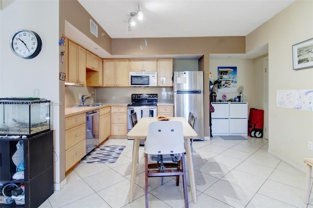 kitchen featuring light brown cabinets, stainless steel appliances, and light tile patterned floors