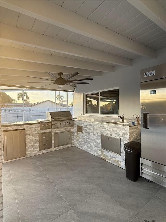 patio terrace at dusk featuring sink, area for grilling, ceiling fan, and exterior kitchen