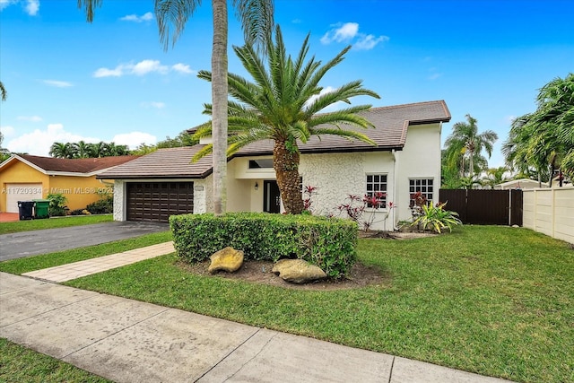 view of front of property with a front yard and a garage