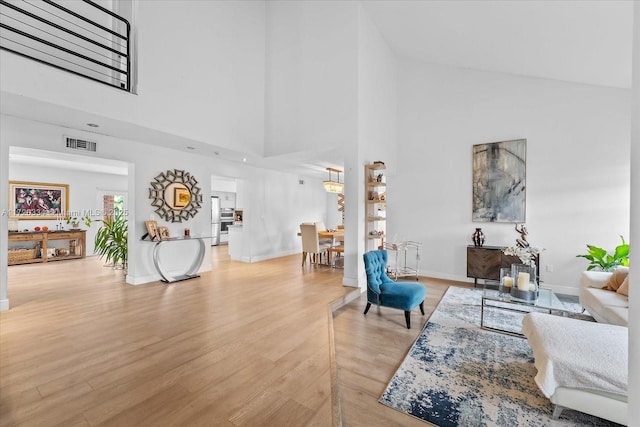 living room featuring a high ceiling and light hardwood / wood-style flooring