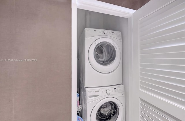 clothes washing area featuring stacked washer / dryer