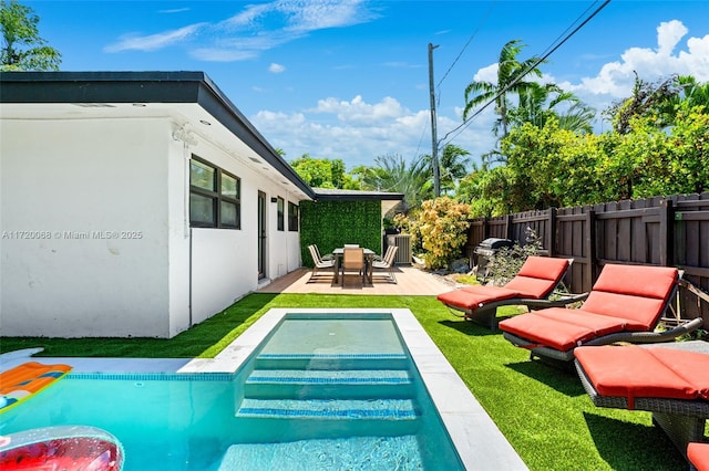 view of pool with a patio, area for grilling, and a lawn