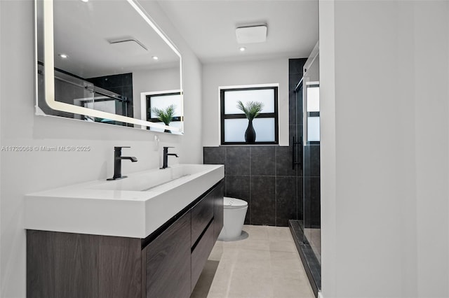 bathroom with vanity, a shower with door, tile walls, tile patterned flooring, and toilet