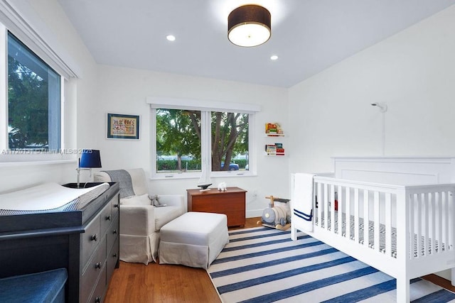 bedroom featuring a crib and dark hardwood / wood-style floors