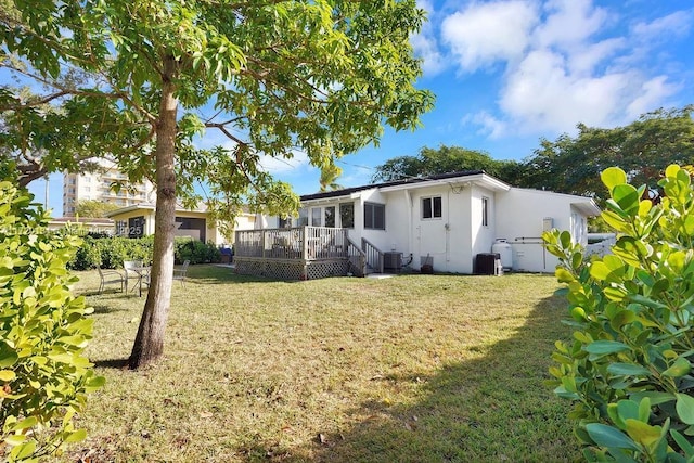 back of house with a yard, a deck, and cooling unit