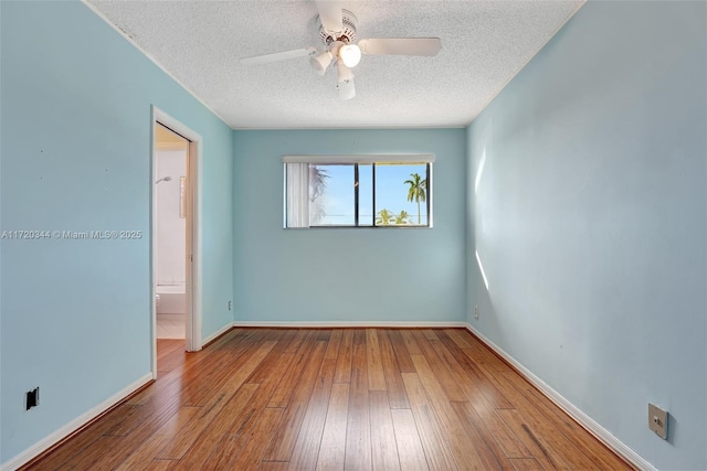 spare room with ceiling fan, a textured ceiling, and hardwood / wood-style flooring