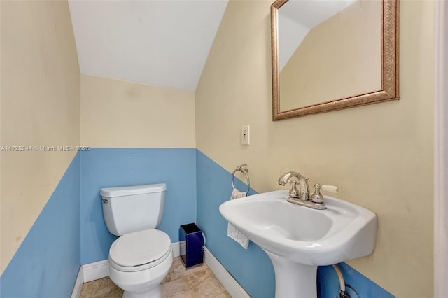 bathroom with sink, vaulted ceiling, and toilet