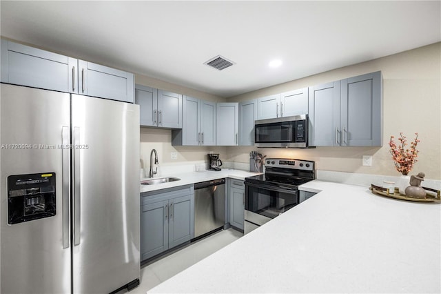 kitchen with stainless steel appliances, gray cabinets, and sink