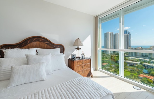 bedroom with floor to ceiling windows and a water view