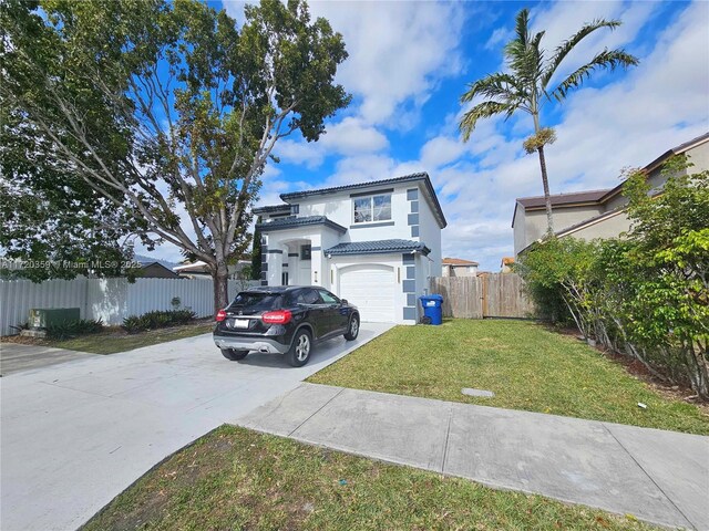 mediterranean / spanish house with a front lawn and a garage