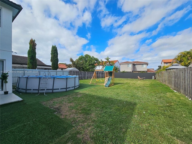 view of yard with a fenced in pool and a playground