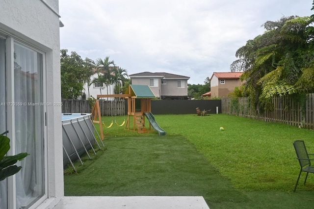 view of yard featuring a pool and a playground