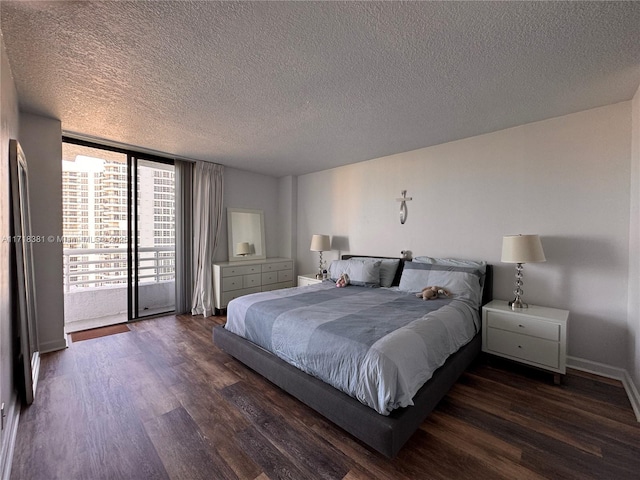 bedroom with dark hardwood / wood-style floors, expansive windows, access to exterior, and a textured ceiling