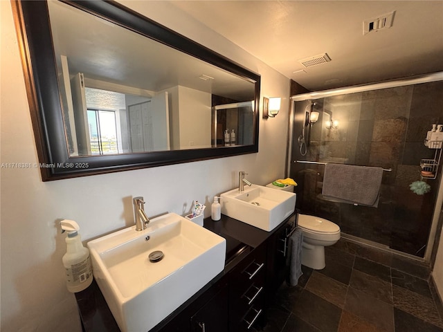 bathroom featuring vanity, toilet, and a shower with door