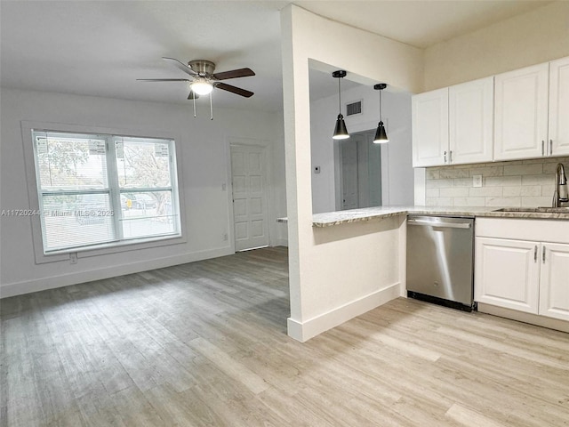 kitchen with tasteful backsplash, white cabinetry, sink, stainless steel dishwasher, and light hardwood / wood-style floors