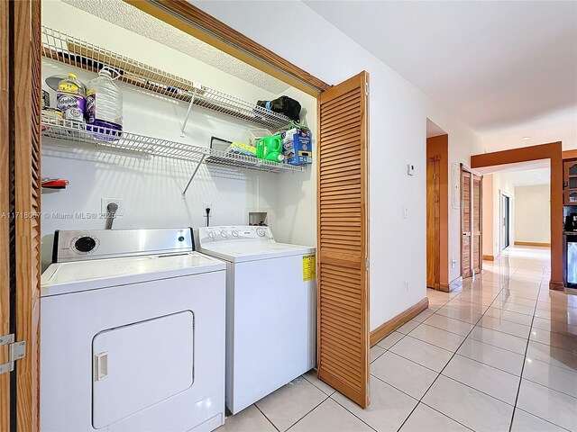 laundry area featuring independent washer and dryer and light tile patterned flooring