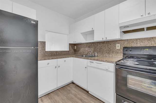 kitchen with sink, tasteful backsplash, white cabinets, black appliances, and light wood-type flooring