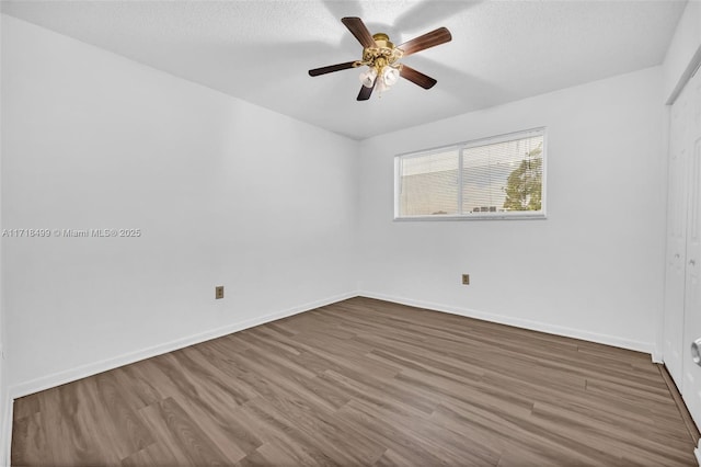 spare room featuring ceiling fan, wood-type flooring, and a textured ceiling