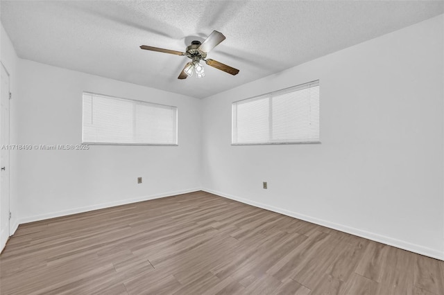 unfurnished room with ceiling fan, light hardwood / wood-style floors, and a textured ceiling