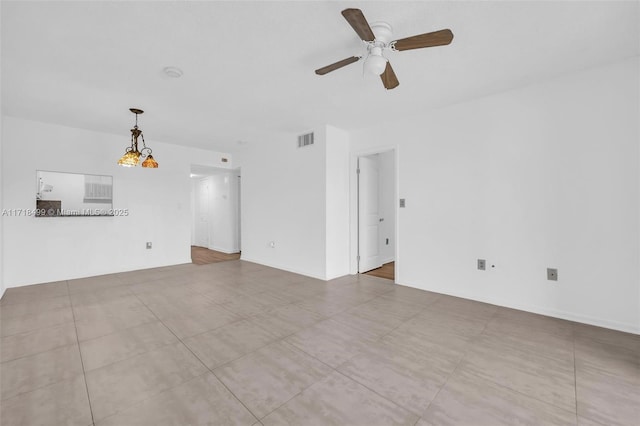 unfurnished living room with ceiling fan with notable chandelier