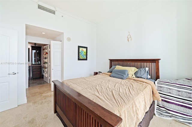 bedroom with ornamental molding and ensuite bath