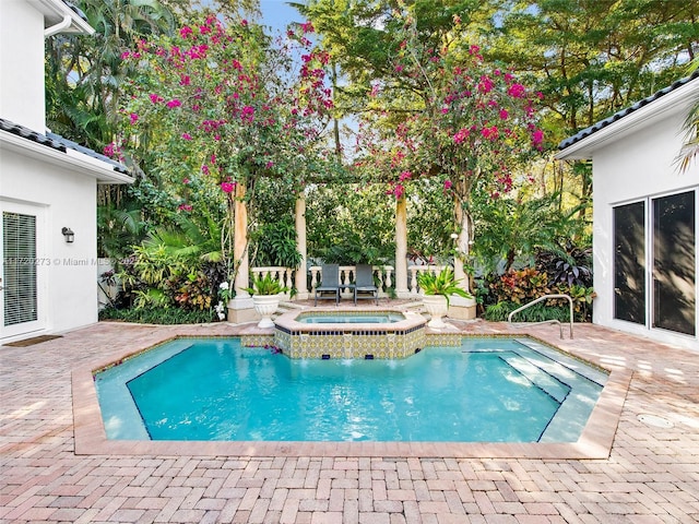 view of pool with an in ground hot tub and a patio