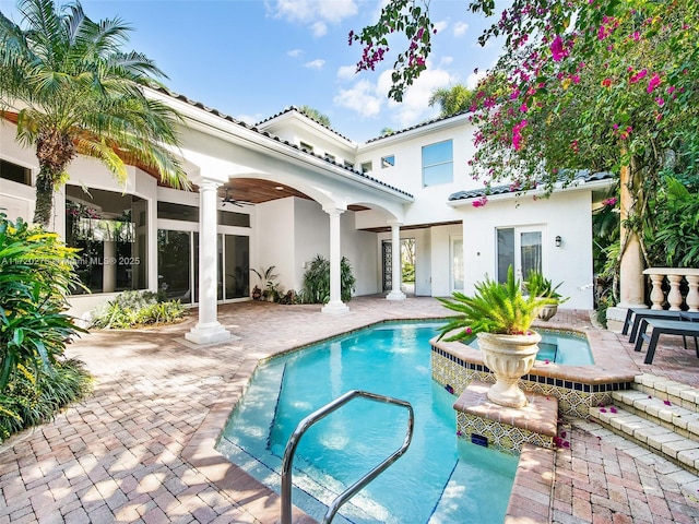 rear view of property featuring ceiling fan and a patio area