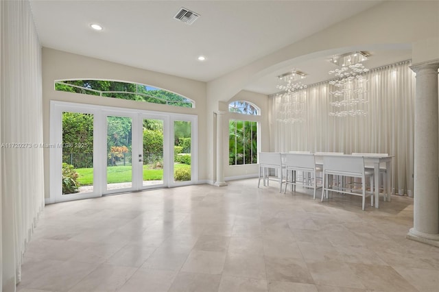 unfurnished sunroom featuring a chandelier and french doors