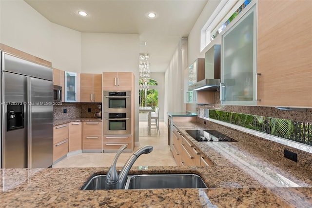 kitchen featuring stone countertops, light brown cabinets, sink, and stainless steel appliances