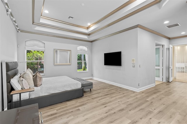 bedroom with light hardwood / wood-style floors, a raised ceiling, and ornamental molding