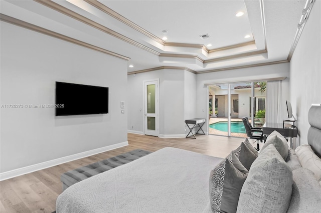 bedroom with light hardwood / wood-style floors, access to exterior, ornamental molding, and a tray ceiling