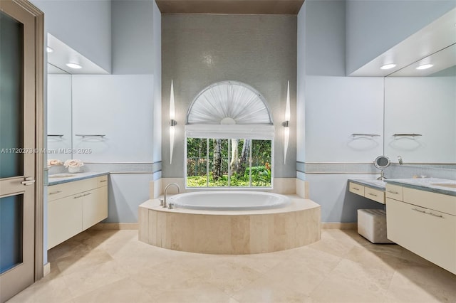 bathroom featuring vanity and a relaxing tiled tub