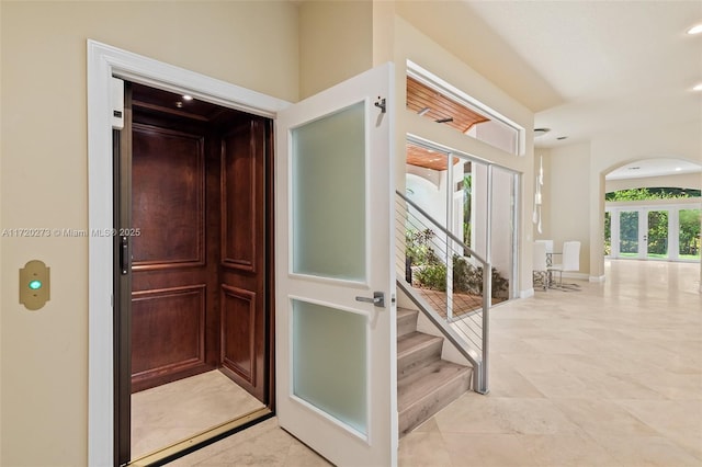 interior space with plenty of natural light, elevator, and french doors