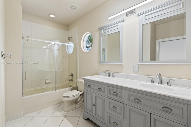 full bathroom featuring shower / bath combination with glass door, tile patterned floors, vanity, and toilet