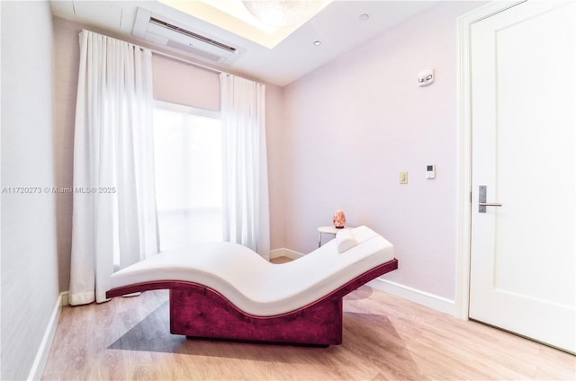 sitting room with a wall mounted AC and light hardwood / wood-style floors