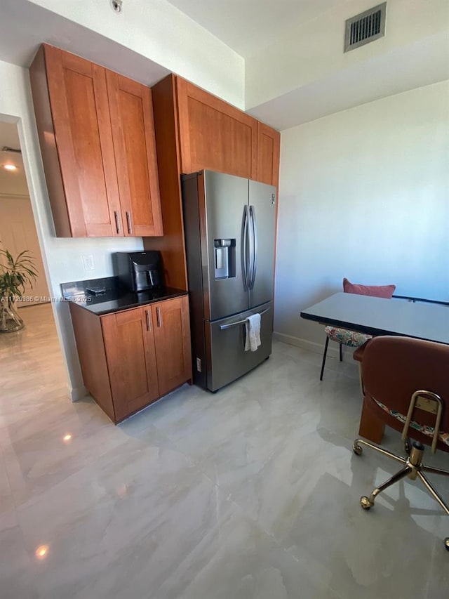 kitchen featuring stainless steel refrigerator with ice dispenser